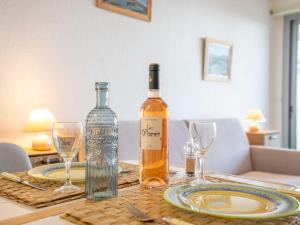 Studio Les Louvans-3 by Interhome في سانت أي جولف: زجاجة من النبيذ موضوعة على طاولة مع أكواب