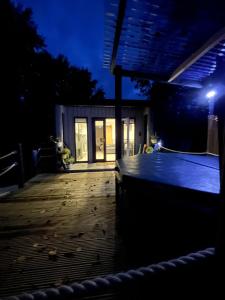 a night view of a deck with a house at Back to Nature Squirrels Lodge 1 bedroom lodge in South Molton