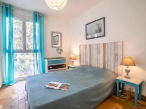 um quarto com uma cama com um livro em Apartment Les Louvans-4 by Interhome em Saint-Aygulf