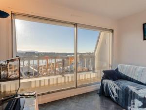 ein Wohnzimmer mit einem großen Fenster und einem Sofa in der Unterkunft Apartment Cap Cabourg-22 by Interhome in Cabourg