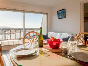 einen Esstisch mit einer Flasche Wein und ein Fenster in der Unterkunft Apartment Cap Cabourg-22 by Interhome in Cabourg