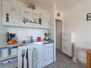 cocina con armarios blancos, fregadero y nevera en Studio Le Grand Galion-1 by Interhome, en Le Grau-du-Roi