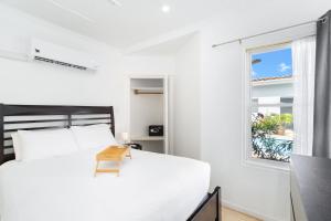 une chambre avec un lit blanc et une fenêtre dans l'établissement Little Paradise 1 - Prikichi, à Noord