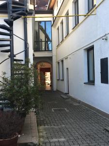 an alleyway between two white buildings with a balcony at Penzion nad Bankou in Košice