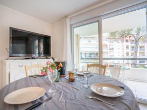 een eetkamer met een tafel en een groot raam bij Apartment Le Grand Parc-6 by Interhome in Saint-Aygulf