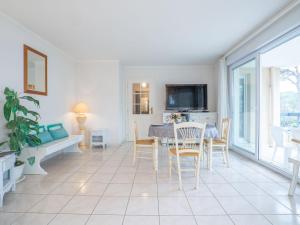 een woonkamer met een tafel en stoelen en een televisie bij Apartment Le Grand Parc-6 by Interhome in Saint-Aygulf