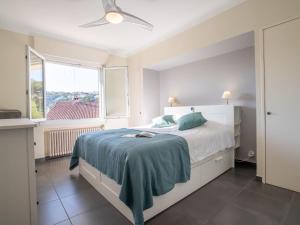 a white bedroom with a bed and a window at Holiday Home Gisele by Interhome in Saint-Aygulf