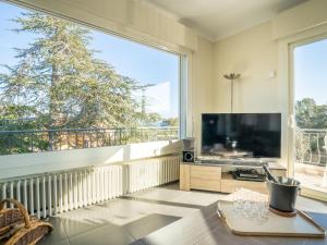 uma sala de estar com uma grande janela e uma grande televisão em Holiday Home Gisele by Interhome em Saint-Aygulf