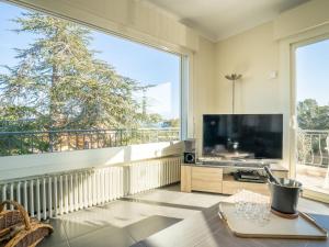 a living room with a large window and a large television at Holiday Home Gisèle by Interhome in Saint-Aygulf