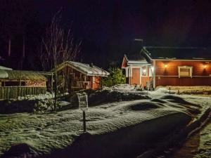 einen schneebedeckten Hof mit einem Haus in der Nacht in der Unterkunft Holiday Home Eemeli by Interhome in Puomila