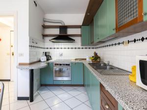 una cocina con armarios verdes y fregadero en Apartment Gallesio - FLG213 by Interhome en Finale Ligure