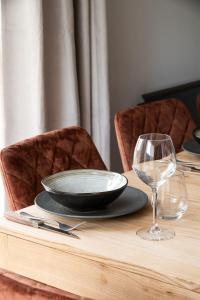 a wooden table with a plate and a glass at Chalet des bois de Criou in Morillon