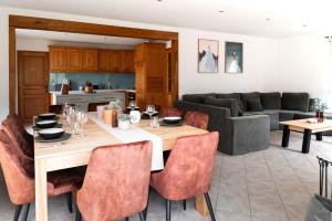 a dining room and living room with a table and chairs at Chalet des bois de Criou in Morillon