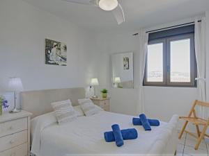 ハベアにあるApartment Galicia Javea-2 by Interhomeの白いベッドルーム(青い枕付きのベッド付)