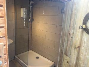 a bathroom with a shower with a phone in it at We have a choice of 1 of 3 separate rooms in our home, a double room upstairs, a large double with en suite downstairs or a bar b q lodge in the garden with its own toilet and shower facilities please book the room you would like to stay in in Portishead