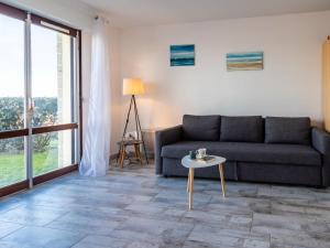 een woonkamer met een bank en een tafel bij Apartment Les Caravelles-5 by Interhome in Cabourg