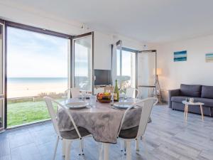 a dining room with a table and chairs and the ocean at Apartment Les Caravelles-5 by Interhome in Cabourg