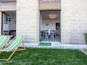 deux chaises assises sur l'herbe devant une maison dans l'établissement Apartment Les Caravelles-5 by Interhome, à Cabourg