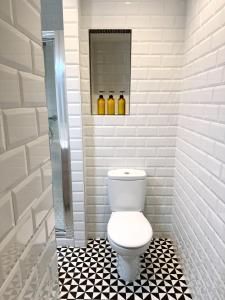La salle de bains est pourvue de toilettes et de carrelage noir et blanc. dans l'établissement Modern City Centre Two Bedroom Windsor Apartment - Grand Central House, à Gibraltar