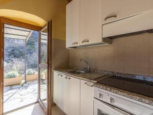 una cocina con armarios blancos y fregadero en Apartment Agriturismo Il Vecchio Mulino by Interhome, en Tavole