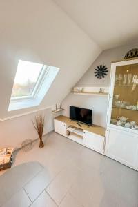 a attic living room with a tv and a window at Apartment Dori by Interhome in Westerholt