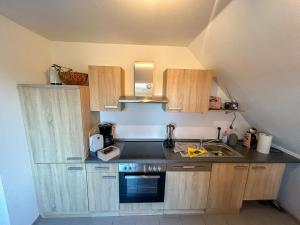 a small kitchen with wooden cabinets and a sink at Apartment Dori by Interhome in Westerholt