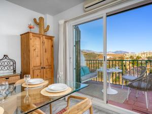 a dining room with a glass table and a balcony at Apartment Angel Blanco by Interhome in La Cala de Mijas