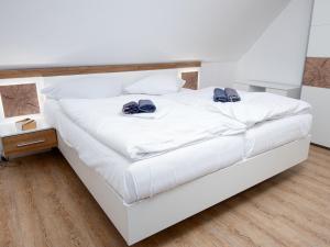 Una cama blanca con dos arcos azules. en Apartment Ankerplatz by Interhome, en Norddeich