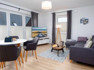 sala de estar con sofá, mesa y TV en Apartment Ankerplatz by Interhome, en Norddeich