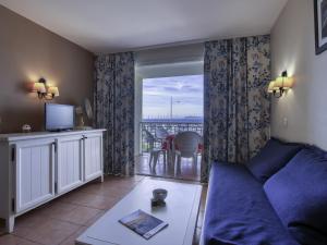 un salon avec un canapé et un balcon dans l'établissement Apartment Les Rivages de Coudoulière-31 by Interhome, à Six-Fours-les-Plages