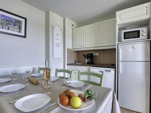 - une cuisine avec une table et une assiette de fruits dans l'établissement Apartment Les Rivages de Coudoulière-31 by Interhome, à Six-Fours-les-Plages