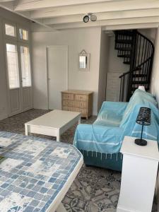 a room with two beds and a table and a staircase at Maison centre ville - 7332 in Soulac-sur-Mer