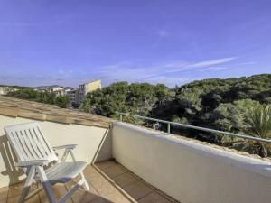 une chaise sur un balcon avec vue sur les arbres dans l'établissement Apartment Les Rivages de Coudoulière-16 by Interhome, à Six-Fours-les-Plages