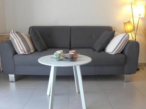 ein Wohnzimmer mit einem Sofa und einem weißen Tisch in der Unterkunft Apartment les Terrasses de Capbreton-2 by Interhome in Capbreton