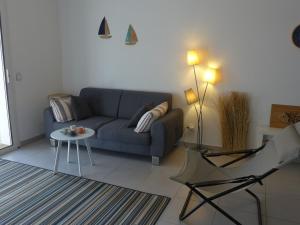 a living room with a blue couch and a table at Apartment les Terrasses de Capbreton-2 by Interhome in Capbreton