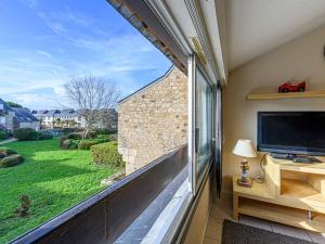 a balcony with a large window and a tv at Studio Maison Port En Dro-5 by Interhome in Carnac