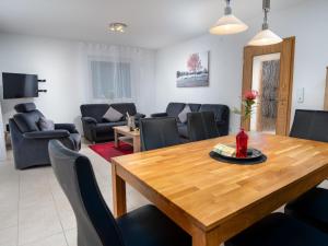 a living room with a wooden table and chairs at Holiday Home Nilles by Interhome in Norddeich