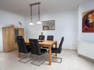 een eetkamer met een houten tafel en zwarte stoelen bij Holiday Home Nilles by Interhome in Norddeich +41 foto's