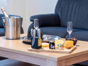 een tafel met een dienblad met kaas en wijnglazen bij Holiday Home Nilles by Interhome in Norddeich