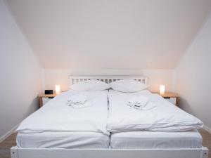 - un lit blanc avec des draps et des oreillers blancs dans l'établissement Holiday Home Nilles by Interhome, à Norddeich