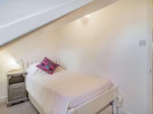 a bedroom with a bed with a pink pillow on it at 4 Bed in Holt 87148 in Holt