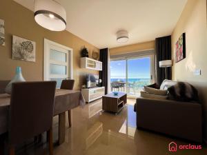een woonkamer met een bank, een tafel en een televisie bij Calma y Relax en el Mediterráneo in Cabanes