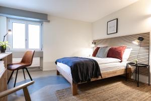 1 dormitorio con cama, escritorio y silla en Grubenmann Appartements - Sankt Gallen Centre, en St. Gallen