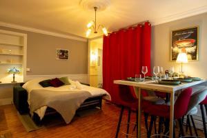 um quarto com uma cama e uma mesa com uma cortina vermelha em Cosy Art Gallery em Reims
