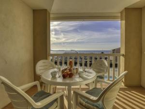 d'une table et de chaises blanches sur un balcon avec vue. dans l'établissement Apartment Les Rivages de Coudoulière-19 by Interhome, à Six-Fours-les-Plages