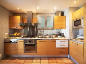 a kitchen with wooden cabinets and a stove top oven at Apartment Vilas Mouriscas by Interhome in Vilamoura