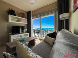 een woonkamer met een bank en uitzicht op de oceaan bij Calma y Relax en el Mediterráneo in Cabanes