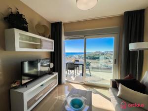 een woonkamer met een tv en een glazen schuifdeur bij Calma y Relax en el Mediterráneo in Cabanes