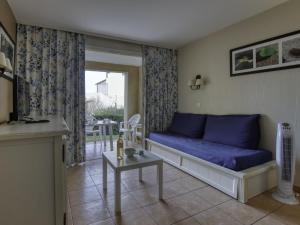 un salon avec un canapé bleu et une table dans l'établissement Apartment Les Rivages de Coudoulière-9 by Interhome, à Six-Fours-les-Plages