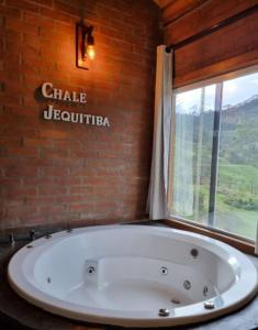 a large bath tub in a room with a window at Chalé Jequitibá- Valedaspedrasmg in Sapucaí-Mirim